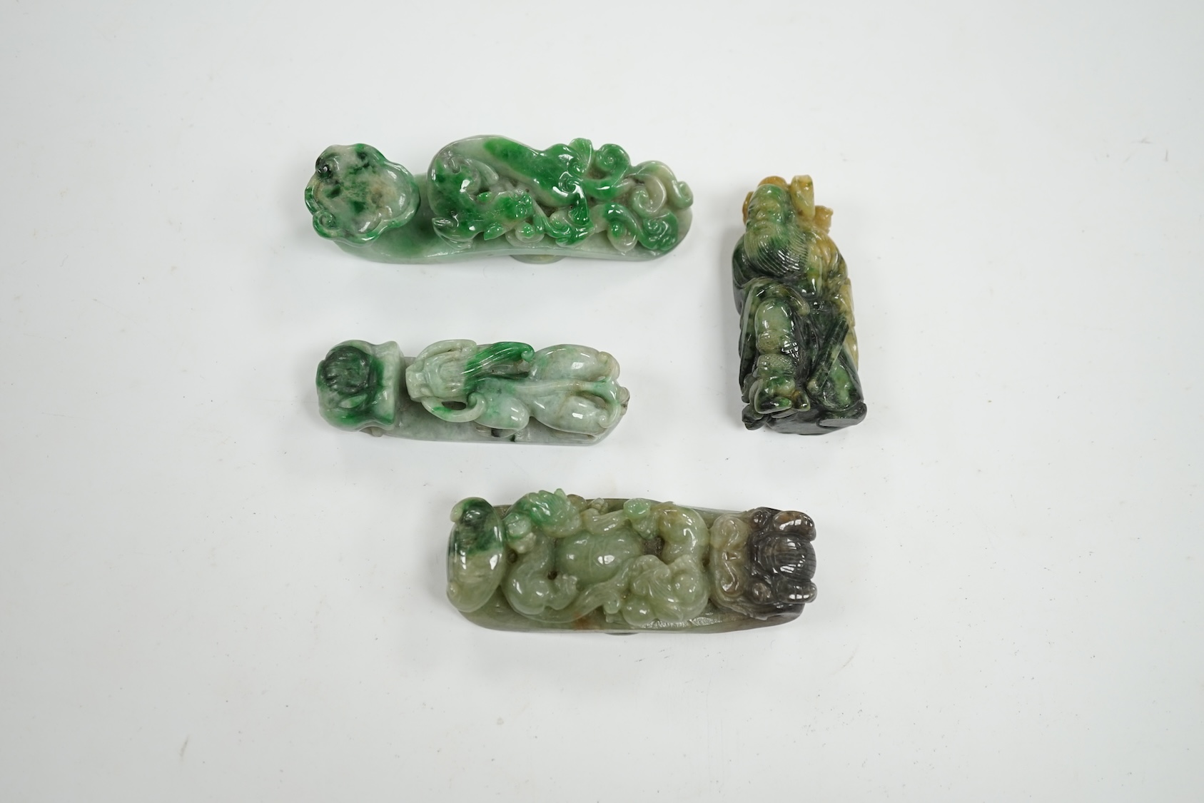 Four Chinese green bowenite jade carvings and belt hooks, largest 9.5cm in length. Condition - good